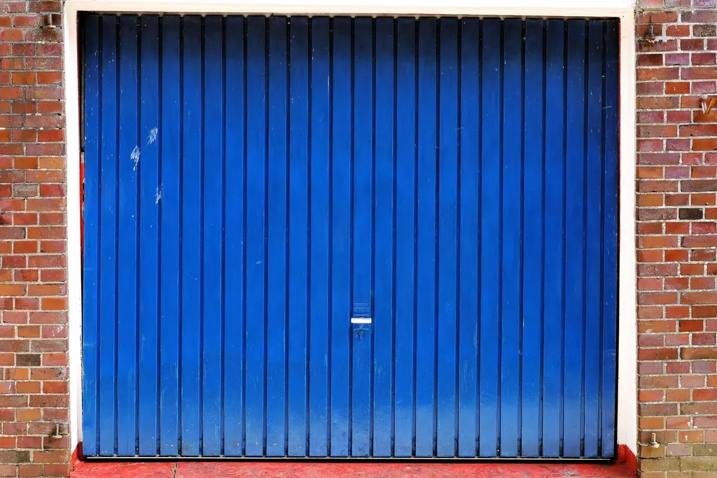 Blue steel garage door framed by brick