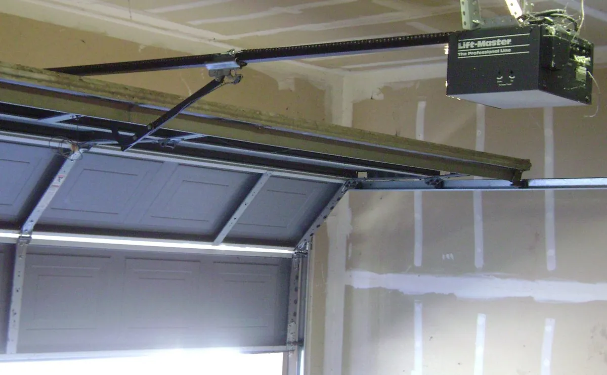 Garage ceiling with an opener motor and rail above a sectional door